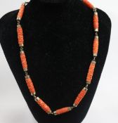 A yellow metal and carved coral baton link necklace, 44cm.