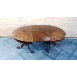 A VICTORIAN MAHOGANY OVAL DINING TABLE the twin turned pedestals raised on outswept tripod supports,