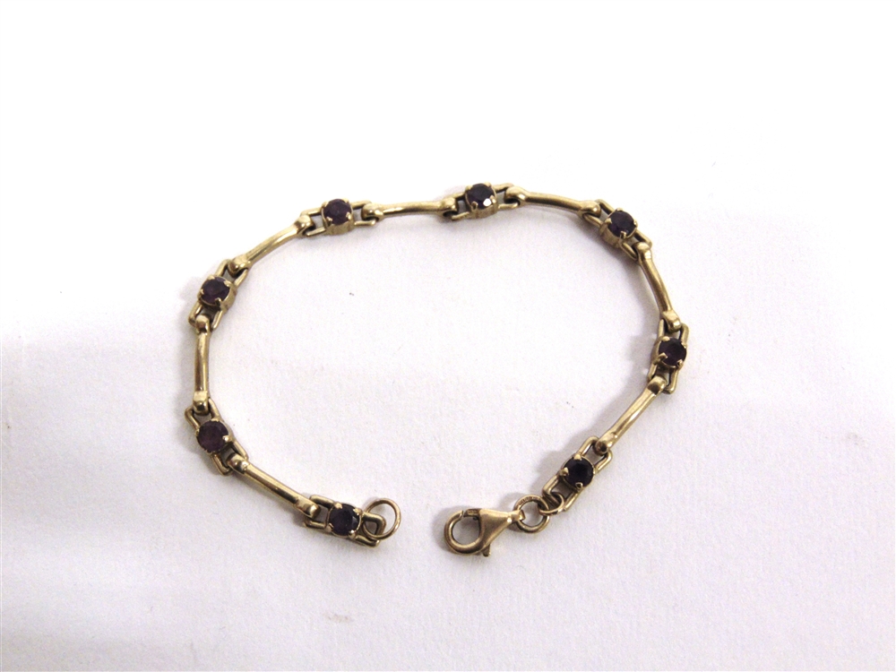 A 9 CARAT GOLD AMETHYST BRACELET the eight stones to stirrups and baton type links, 18cm long, 8.