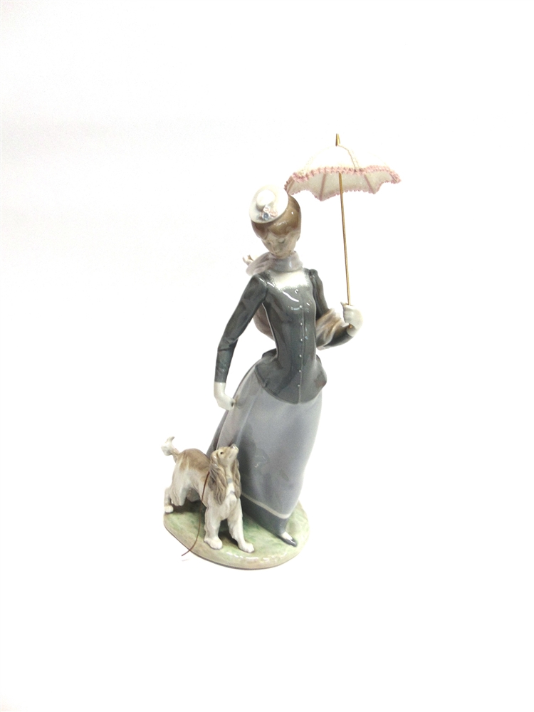 A LARGE LLADRO FIGURE OF A LADY walking a dog whilst holding a parasol, 43cm high