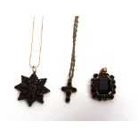 A 9 CARAT GOLD GARNET CROSS PENDANT on a 9 carat gold chain; with a star shaped garnet cluster