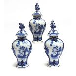 THREE MATCHING DUTCH DELFT LIDDED VASES each decorated with a reserve depicting a gentleman