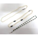 A ROW OF UNIFORM CULTERED PEARLS with pairs of black examples in three places; a row of uniform