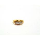 A FOUR STONE DIAMOND RING stamped '750', set with graduated old cuts totalling approximately 0.2
