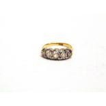 A LATE VICTORIAN FIVE STONE DIAMOND RING stamped '18ct', the silver collet set old brilliant cuts