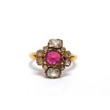 A RUBY AND DIAMOND CLUSTER RING the oval cut stone, approximately 6.5mm by 6mm by 1.6mm deep, with