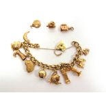 A 9 CARAT GOLD BRACELET of solid curb links, to a padlocked clasp, with ten charms attached, and