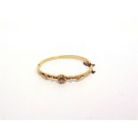AN EDWARDIAN SEED PEARL AND DIAMOND HINGED BANGLE the central cluster with an old cut diamond of