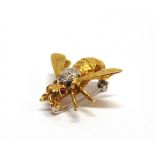 A DIAMOND AND RUBY BEE BROOCH stamped '750', the thorax set with seven single cut diamonds, rub