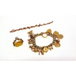 A PLATED BRACELET with various charms attached including a 22 carat gold wedding ring; a 9 carat