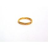 A 22 CARAT GOLD RING set with eight small brilliant cuts, totalling approximately 0.12 carats,