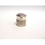 A VICTORIAN EMBOSSED SILVER BOX by William Comyns, London 1894, of cylindrical form with pull off