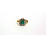 AN EMERALD AND DIAMOND 18 CARAT GOLD RING the step cut approximately 6.4 x 5.2 x 3.3mm deep,