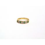 A 9 CARAT GOLD FOUR STONE EMERALD HALF ETERNITY RING with pairs of single cut diamonds in between,