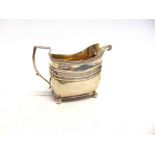 A GEORGE III SILVER CREAM JUG makers mark worn, London 1808, of rounded rectangular outline, on ball