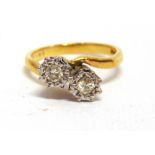 A TWO STONE CROSSOVER 18 CARAT GOLD RING the illusion set brilliant cuts totalling approximately 0.2