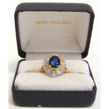A SAPPHIRE AND DIAMOND 'BALLERINA' CLUSTER RING stamped '750', the oval cut stone, 9 by 6.8 by 4.5mm