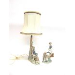 A LLADRO FIGURAL LAMP BASE modelled as a girl sitting beside a tree trunk, 30cm high (excluding