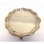 A SILVER SALVER Sheffield 1929, of circular shaped outline with a moulded rim, on three supports,