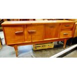 A TEAK SIDEBOARD fitted with two-door cupboard to left, drop-down cupboard and two drawers to right,