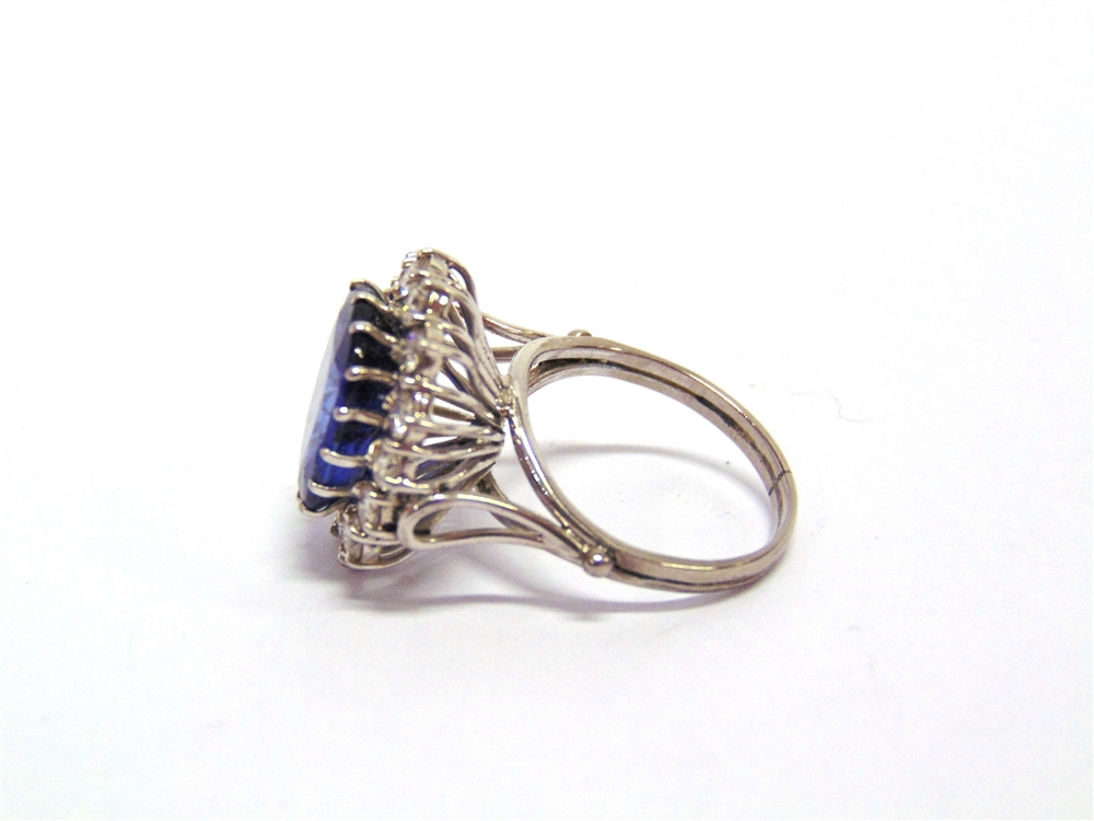 A SAPPHIRE AND DIAMOND CLUSTER RING the white mount unmarked, the rectangular cut stone, 13.6mm by - Image 2 of 2