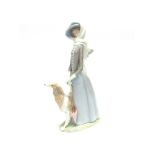 A LARGE LLADRO GROUP of a lady walking her dog, a parasol in her hands, 41cm high