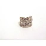 A 9 CARAT GOLD DIAMOND DRESS RING of crossover design with lines of brilliant and single cuts, the