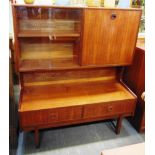 A TURNIDGE TEAK BUREAU CABINET with drop-down fitted cupboard and glazed section above two drawers