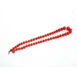 A GRADUATED ROW OF CORAL BEADS the forty-nine slightly spherical beads of approximately 8/17mm