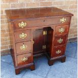 A GEORGIAN MAHOGANY KNEEHOLE DESK with long drawer above six pedestal drawers, with brass loop