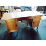 A COTSWOLDS SCHOOL OAK DESK each pedestal with fielded panelled door enclosing sliding trays,