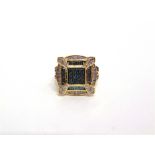 A 9 CARAT GOLD DIAMOND AND BLUE DIAMOND CLUSTER RING set with single cuts and baguettes, diamond set