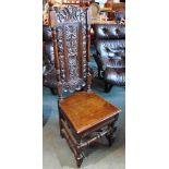 A CARVED DARK OAK HIGH BACK CHAIR the carved panelled back rest flanked by turned supports with