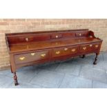 AN 18TH CENTURY OAK DRESSER BASE the low backrest with three short drawers and fitted with three