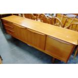 A FORMICA SIDEBOARD the central cupboard flanked by three drawers and drop-down cupboard on sledge