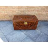 A CAMPHORWOOD TRUNK the lid and front carved with scenes of sailing boats flanked by serpents,