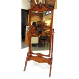 A MAHOGANY FRAMED CHEVAL MIRROR the serpentine fronted base raised on four scroll supports with