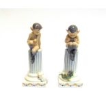 A PAIR OF ROYAL COPENHAGEN MODELS OF FAUNS by Christian Thomsen, both seated on columns, one holding