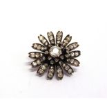 A LATE VICTORIAN DIAMOND SET FLOWER HEAD BROOCH the principal diamond of approximately 1 carat,