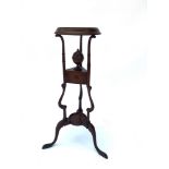 A GEORGIAN STYLE WIG STAND with small shaped drawer, and on three outswept supports. 82cms high