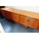 A G-PLAN 'FRESCO' TEAK SIDEBOARD with four drawers flanked to each side by cupboards, 214cm long