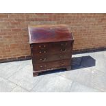 A GEORGIAN MAHOGANY BUREAU the fall front opening to reveal a central cupboard flanked by pigeon