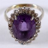 AN AMETHYST AND DIAMOND CLUSTER RING the white mount stamped '18ct', the oval cut, 13.6 by 10.6 by
