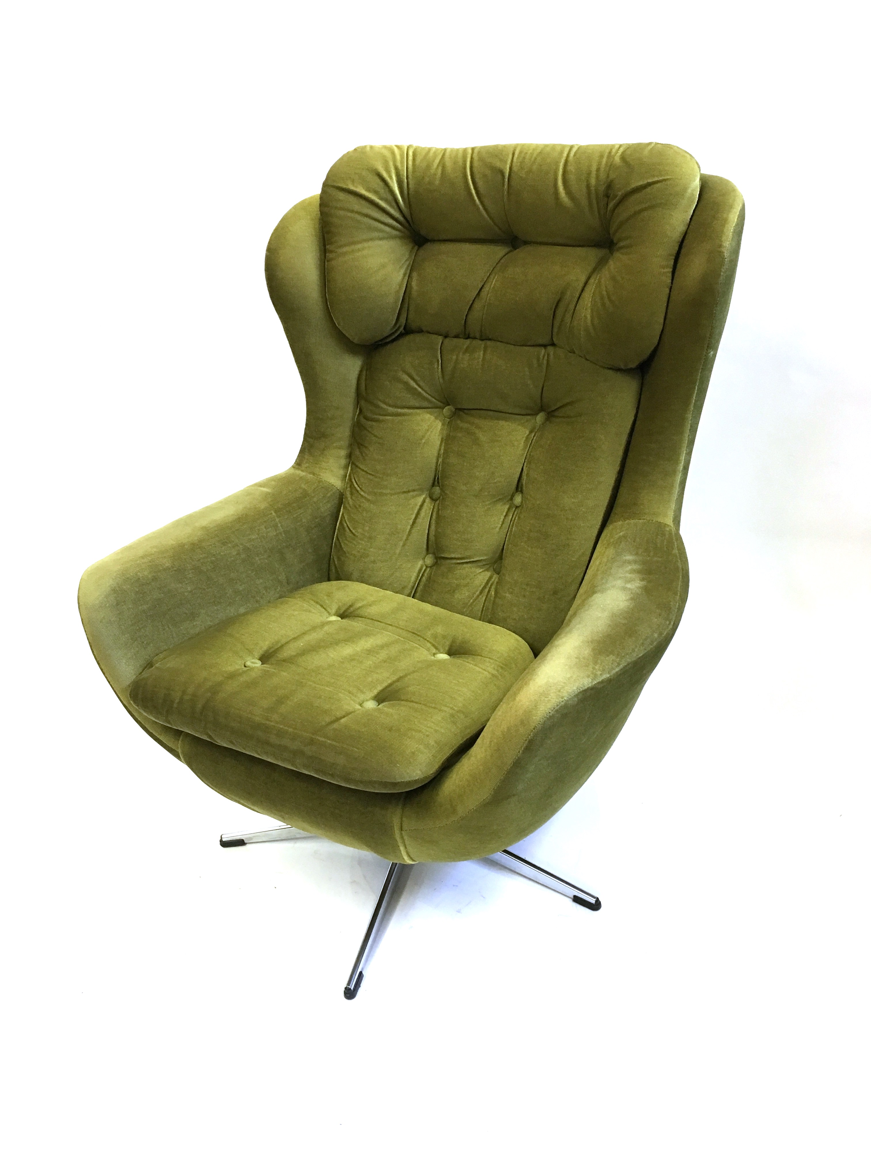 A 1970S SWIVEL ARMCHAIR with green button upholstery on chrome five prong base