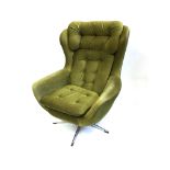 A 1970S SWIVEL ARMCHAIR with green button upholstery on chrome five prong base