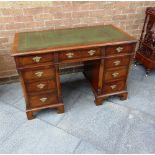 A RECTANGULAR MAHOGANY WRITING DESK with green inset leather top, and fitted with three frieze