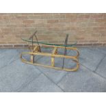 A VINTAGE WOODEN SLED with metal runners, adapted as a coffee table
