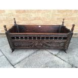 AN OAK AND PITCH PINE ROCKING CRIB with foliate carved decoration, bearing date '1731', 101cm long