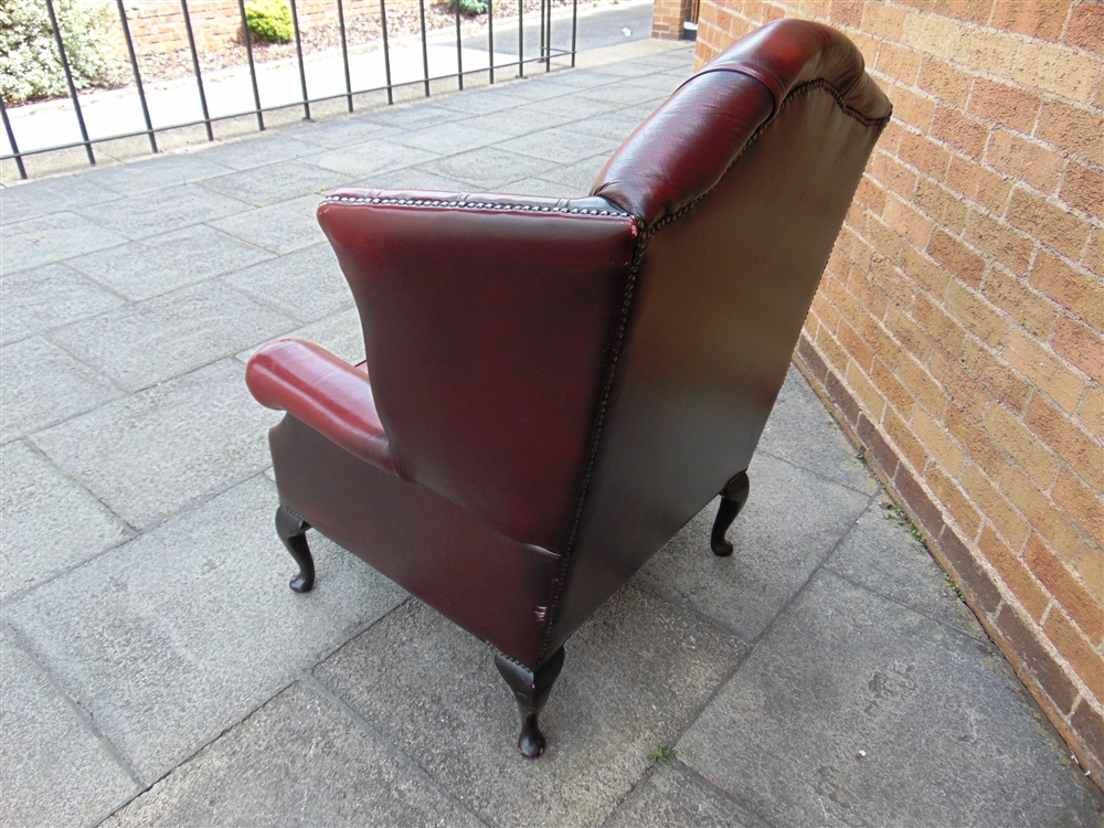 AN UPHOLSTERED RED LEATHER WING ARMCHAIR buttoned and studded and raised on four cabriole - Image 2 of 2