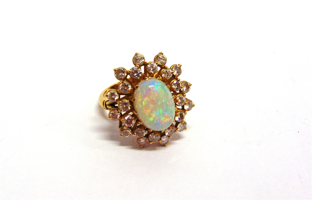 AN OPAL AND DIAMOND CLUSTER RING stamped '18KT', the oval cabochon enclosed by twenty four brilliant